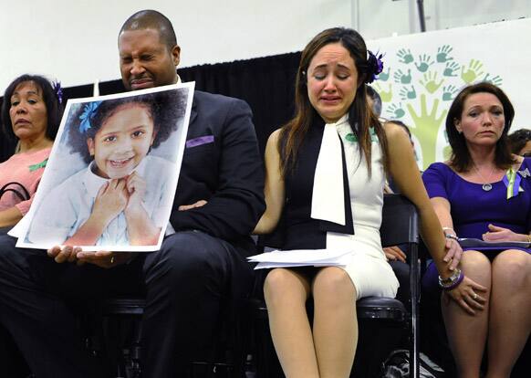 Jimmy Greene, foreground left, Nelba Marquez-Greene, center, parents of Sandy Hook Elementary School shooting victim Ana Marquez-Greene, and Nicole Hockley, right, mother of victim Dylan Hockley, react during a news conference at Edmond Town Hall in Newtown, Conn.
