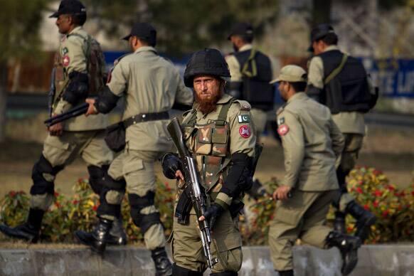 Pakistani troops stand guard as supporters of Pakistani cleric Tahir-ul-Qadri attend a rally, unseen, in Islamabad. Thousands of supporters of a fiery cleric who has been calling for election reforms were descending Monday on the Pakistani capital.