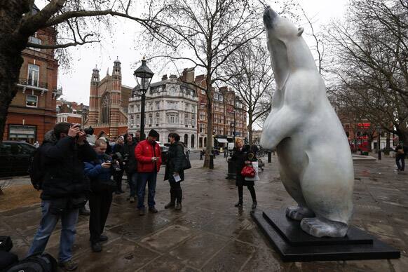 Members of the media gather around a newly unveiled polar bear sculpture called