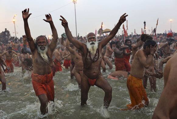 Hindu holy men, or Sadhus, run into the water at Sangam, the confluence of the rivers Ganges, Yamuna and mythical Saraswati, during the royal bath on Makar Sankranti at the start of the Maha Kumbh Mela in Allahabad.