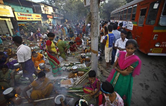 Tamil Hindu devotees cook rice as they prepare special food to celebrate the harvest festival of `Pongal` at the Dharavi Slum of Mumbai.
