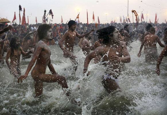 Hindu holy men, or Naga Sadhus, run naked into the water at Sangam, the confluence of the rivers Ganges, Yamuna and mythical Saraswati, during the royal bath on Makar Sankranti at the start of the Maha Kumbh Mela in Allahabad.