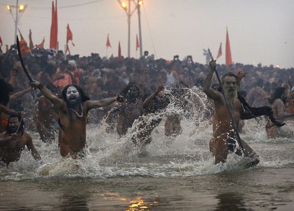 Hindu holy men, or Naga Sadhus, run naked into the water at Sangam, the confluence of the Ganges, Yamuna and mythical Saraswati river, during the royal bath on Makar Sankranti at the start of the Maha Kumbh Mela in Allahabad.