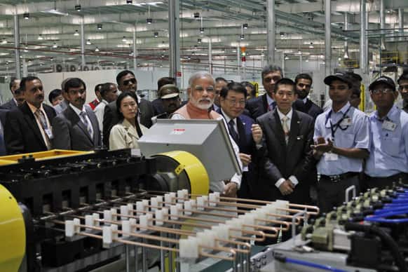 Narendra Modi, CEO of Hitachi Appliances Japan Haruki Yamamoto and MD Motoo Morimoto, watch after the inauguration of the reconstructed manufacturing facility of Hitachi Home and Life Solutions (HHLS), a subsidiary of Hitachi Appliances Inc. Japan, near Kadi, Ahmadabad.