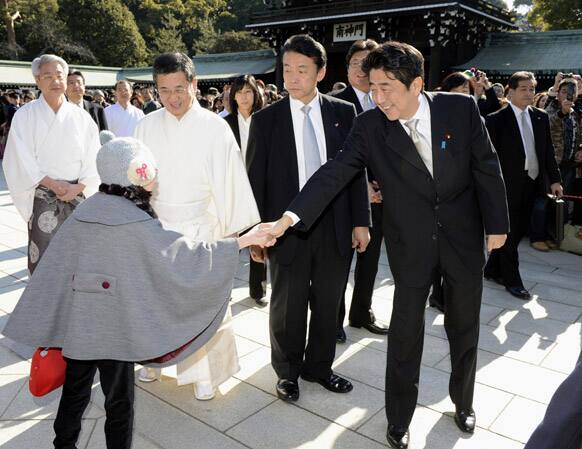 Japanese Prime Minister Shinzo Abe, right, is greeted by a little girl as he visits Meiji Shrine in Tokyo.