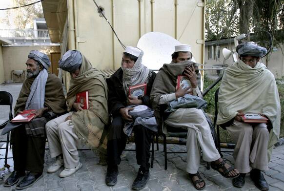 Former Taliban fighters hold copies of the holy Quran as they join sides with the Afghanistan government in the city of Jalalabad, east of Kabul, Afghanistan.