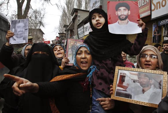 Kashmiris hold portraits of their relatives in various prisons as they participate with activists of Jammu Kashmir Liberation Front in a protest in Srinagar.
