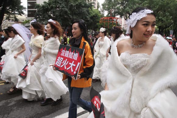 Taiwanese women wear wedding dress and hold slogan reading