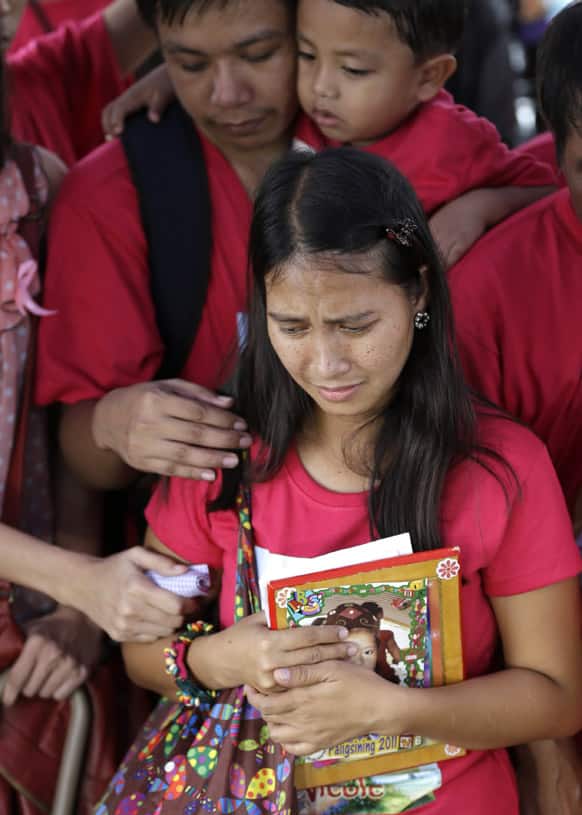 Glen Elaine Ella, grieves as she clutches a photo of her daughter Stephanie Nicole Ella, 7, who was hit with a stray bullet as their family watch the fireworks to welcome the New Year, during her buria, at Norzagaray township, Bulacan province, north of Manila.