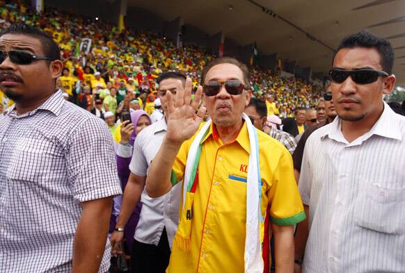 Malaysian opposition leader Anwar Ibrahim, center, waves to supporters as he arrives for the People`s Uprising Rally at Stadium Merdeka in Kuala Lumpur.