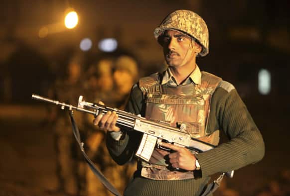 An Indian Border Security Force (BSF) soldier stands guard during a night patrol near international border fencing at Suchet Garh in Ranbir Singh Pura, about 27 kilometers (17 miles) south of Jammu.