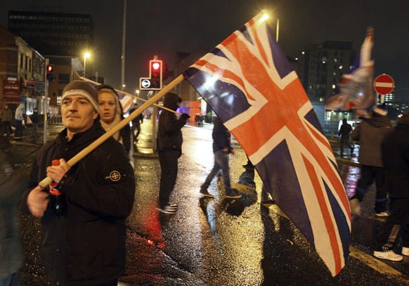 Loyalist protesters hold a British Union flag during clashes with police in the Cloughfern area of Newtownabbey, Belfast, Northern Ireland, during a Union flag protest.