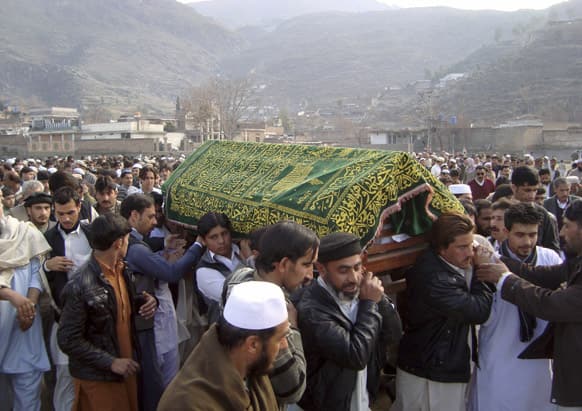 Pakistani relatives and mourners carry the body of one of Thursday`s bombing victims that targeted a mosque in the northwestern Pakistani city of Mingora, Pakistan, during his funeral procession.