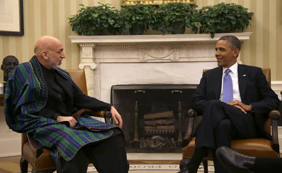 President Barack Obama talks with Afghan President Hamid Karzai during their bilateral meeting in the Oval Office of the White in Washington.