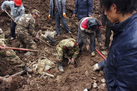 Chinese Paramilitary policemen dig through a landslide to search for victims in the Zhaojiagou village in Zhenxiong county in southwest China`s Yunnan province.