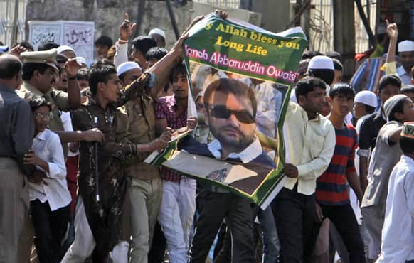 Muslim supporters hold a portrait of Majlis-e-Ittehadul Muslimeen leader Akbaruddin Owaisi and participate in a protest after Friday prayers in Hyderabad.