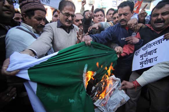 Activists of India’s main opposition Bharatiya Janata Party shout slogans and burn a flag of Pakistan during a protest in Jammu.