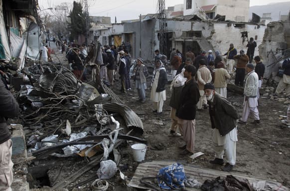 Local residents survey one of the sites of Thursday`s deadly bombings in Quetta. The death toll from a series of deadly bombings across Pakistan rose Friday to at least 120, Pakistani police said, marking one of the deadliest days the country has seen in years.