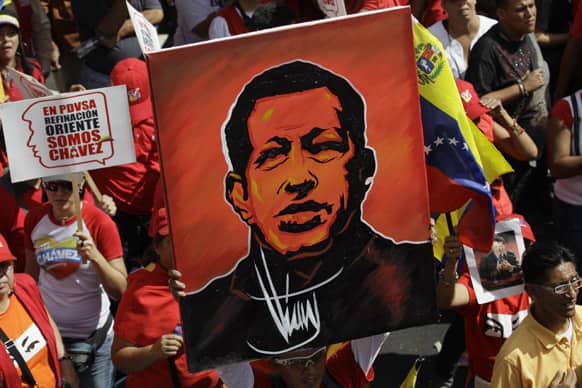 A supporter of Venezuela`s President Hugo Chavez holds up a painting of him during a symbolic inauguration rally for Chavez outside Miraflores presidential palace in Caracas, Venezuela.