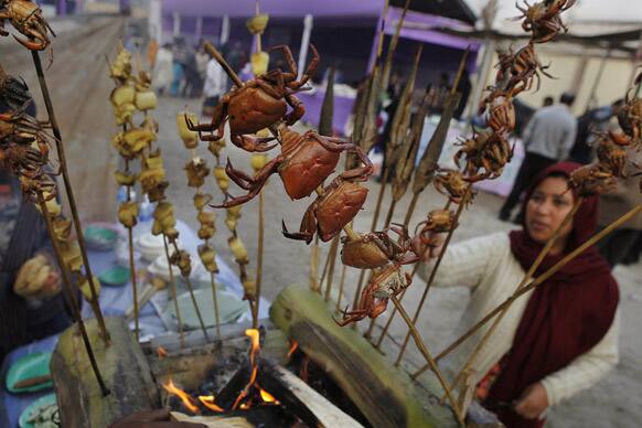 A woman looks at spit-roasted crabs ahead of the Assamese Bhogali Bihu festival in Guwahati. “Bhogali Bihu” is a harvest festival celebrated in Assam which marks the end of the harvesting season. The festival starts on Jan. 13.
