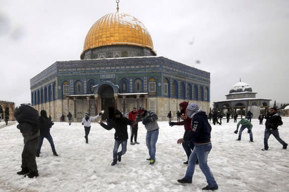 People play in the snow in front of the Dome of the Rock inside the Al-Aqsa Mosque compound in Jerusalem`s Old City. Stormy weather conditions across the region continued on Thursday with snow, torrential rains and strong winds.