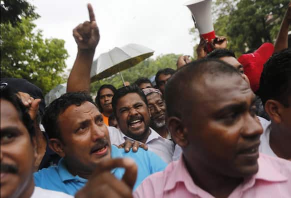 Supporters of Sri Lankan President Mahinda Rajapaksha shout slogans as they block a protest march by Sri Lankan lawyers and opposition groups outside the court complex in Colombo.