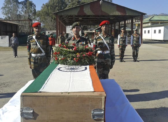 Indian army soldiers offer prayers near the body of a colleague who was allegedly killed by Pakistani soldiers, in Rajouri, India.