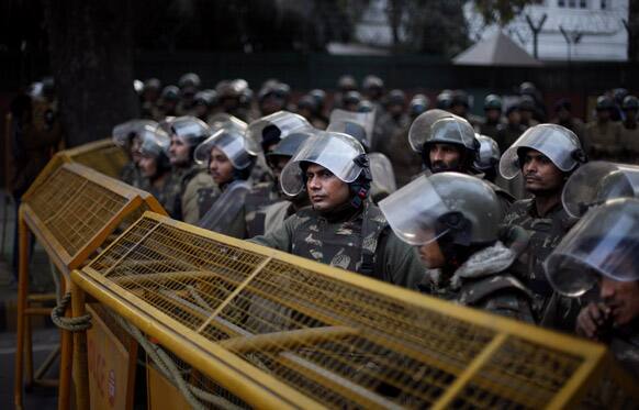 Indian policemen in anti-riot gear stand guard behind police barricades during a protest against Pakistan in New Delhi, India.