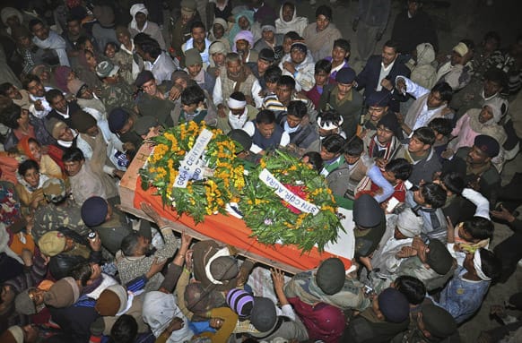 Mourners gather around the body of Indian Army soldier Lance Naik Hamraj who was allegedly killed by Pakistani soldiers on the line-of-control in Kashmir, during his funeral in Mathura district, Utter Pradesh, India.