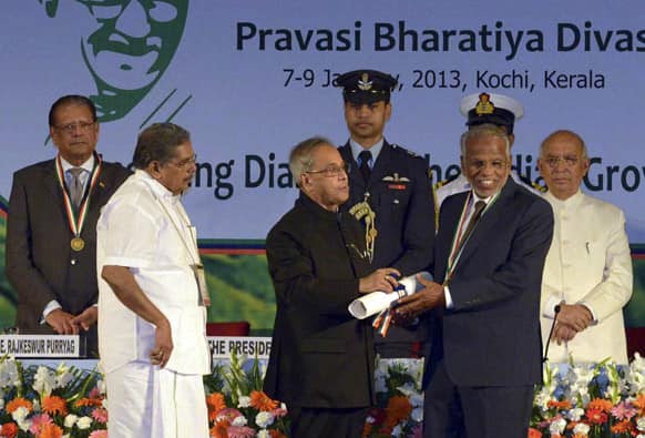 Indian President Pranab Mukherjee, center, honors Bava Pandalingal, right, from United Arab Emirates (UAE) as Union Minister for Overseas affairs, with Vayalar Ravi, left, during the Pravasi Bhartiya Divas (PBD), or non-resident Indian day, in Kochi.
