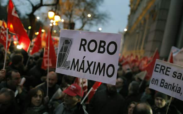 Protestors hold banners reading, `Bankia, big fraud` and `No wild layoffs in Bankia, partly seen, against layoffs in the bank sector outside the Bank of Spain in Madrid, Spain.