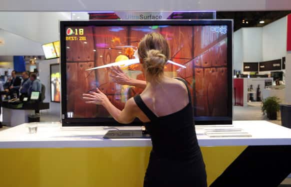 A model plays Fruit Ninja, a popular mobile game, on TCL`s UltraSurface TV at the International Consumer Electronics Show in Las Vegas.