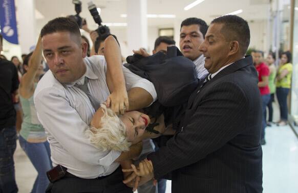 An activist of the group FEMEN is taken away by security guards during a demonstration at a shopping mall in Sao Paulo, Brazil.