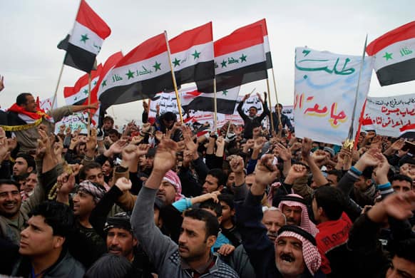 Protesters chant slogans against Iraq`s Shiite-led government as they wave representations of Saddam Hussein-era national flags during a demonstration in Ramadi, 70 miles (115 kilometers) west of Baghdad, Iraq.