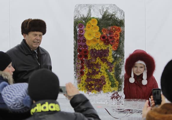 People take pictures near the real ice-covered flowers during the exhibition `Flowers of the Snow Queen` in Kiev, Ukraine.