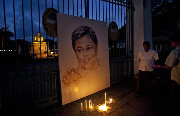 Extended family members and friends light candles next to the portrait of slain newspaper editor Lasantha Wickrematunge, on his fourth death anniversary in Colombo, Sri Lanka.