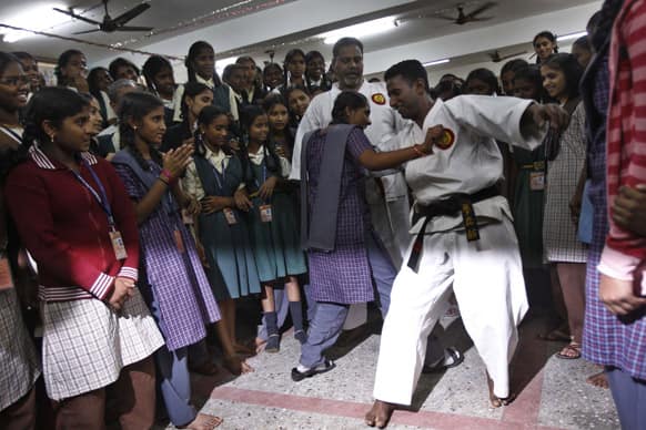 Young Indian school girls participate in a training program at a school as martial art experts demonstrate self defense drill to prevent any attacks on them, in Bangalore.