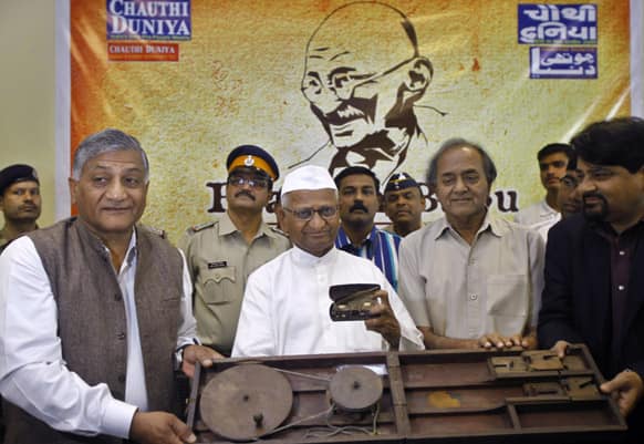 Anti-corruption activist Anna Hazare along with former Indian Army Chief General V.K. Singh display Mahatma Gandhi personal memorabilia after they arrive from London at Mumbai Airport.