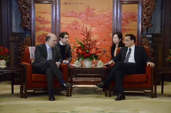 French minister of the Economy Pierre Moscovici, left, chats with Chinese Vice Premier Li Keqiang, right, during their meeting at the Zhongnanhai leaderships compound in Beijing.