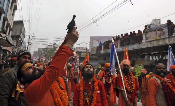 A Naga Sadhu, or Naked Hindu holy man, fires in the air during a religious procession towards the Sangam, the confluence of rivers Ganges, Yamuna and mythical Saraswati, as part of the Mahakumbh festival in Allahabad.