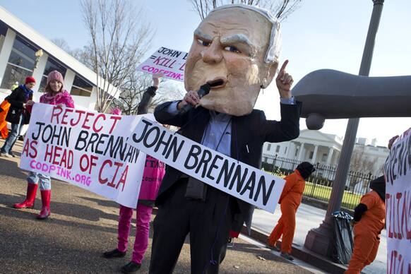Tighe Barry, wearing a John Brennan mask, takes part in a demonstration in front of the White House in Washington.