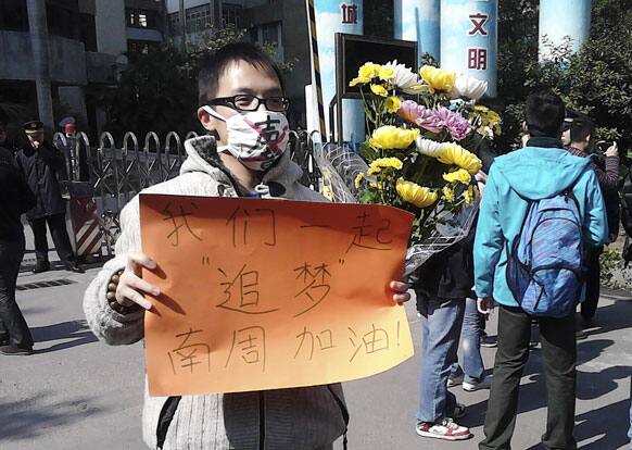 This photo taken and provided by activist Wu Wei, a man wearing a mask with words