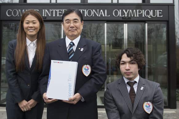 Masato Mizuno, CEO for the Tokyo 2020 Olympic bid, Homare Sawa, four-time Olympian and 2011 FIFA Ballon d`Or winner, Takayuki Suzuki, Paralympic champion in swimming, pose for photographer in front of the IOC headquarter before they submit their candidature bid for 2020 Tokyo Olympic summer games.