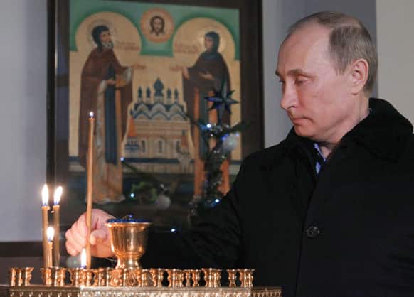 Russian President Vladimir Putin lights a candle as he attends the Christmas service in the Trinity St. George Monastery in Sochi, Russia.