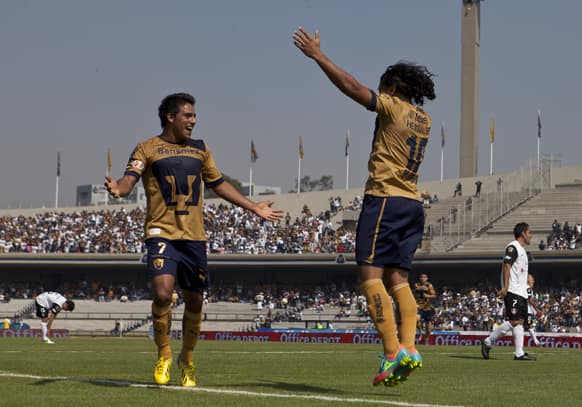 Pumas´ Martin Bravo, right, celebrates with teammate Javier Cortes after scoring against Atlas during a Mexican soccer league match in Mexico City.
