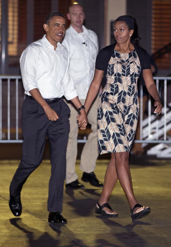 President Barack Obama and first lady Michelle Obama walk across the tarmac to board Air Force One at Honolulu Joint Base Pearl Harbor-Hickam, in Honolulu, en route to Washington after their holiday vacation.