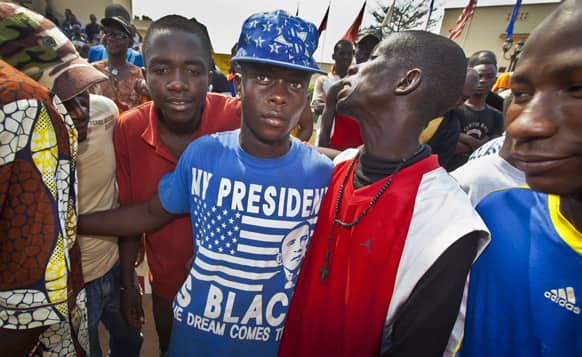 Youths attend a demonstration calling for peace as negotiators prepare for talks with rebels from the north, one wearing a t-shirt with the face of US President Barack Obama and reading