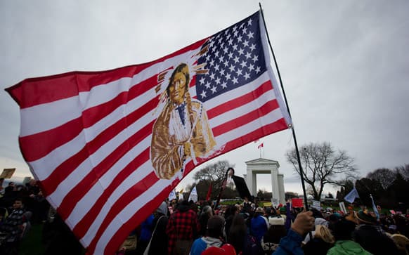 A protester waves a U.S. flag depicting a Native American during a First Nations Idle No More demonstration at the Douglas-Peace Arch crossing at the Canada-U.S. border near Surrey, British Columbia.