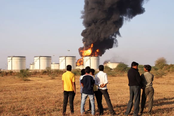 People watch a fire at a petrol storage tank of state-owned Indian Oil Corporation (IOC) near Surat.