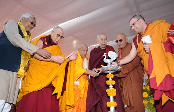 Tibetan spiritual leader the Dalai Lama and Bihar state Chief Minister Nitish Kumar light a lamp with other Buddhist leaders at the Buddha Smriti Park in Patna.